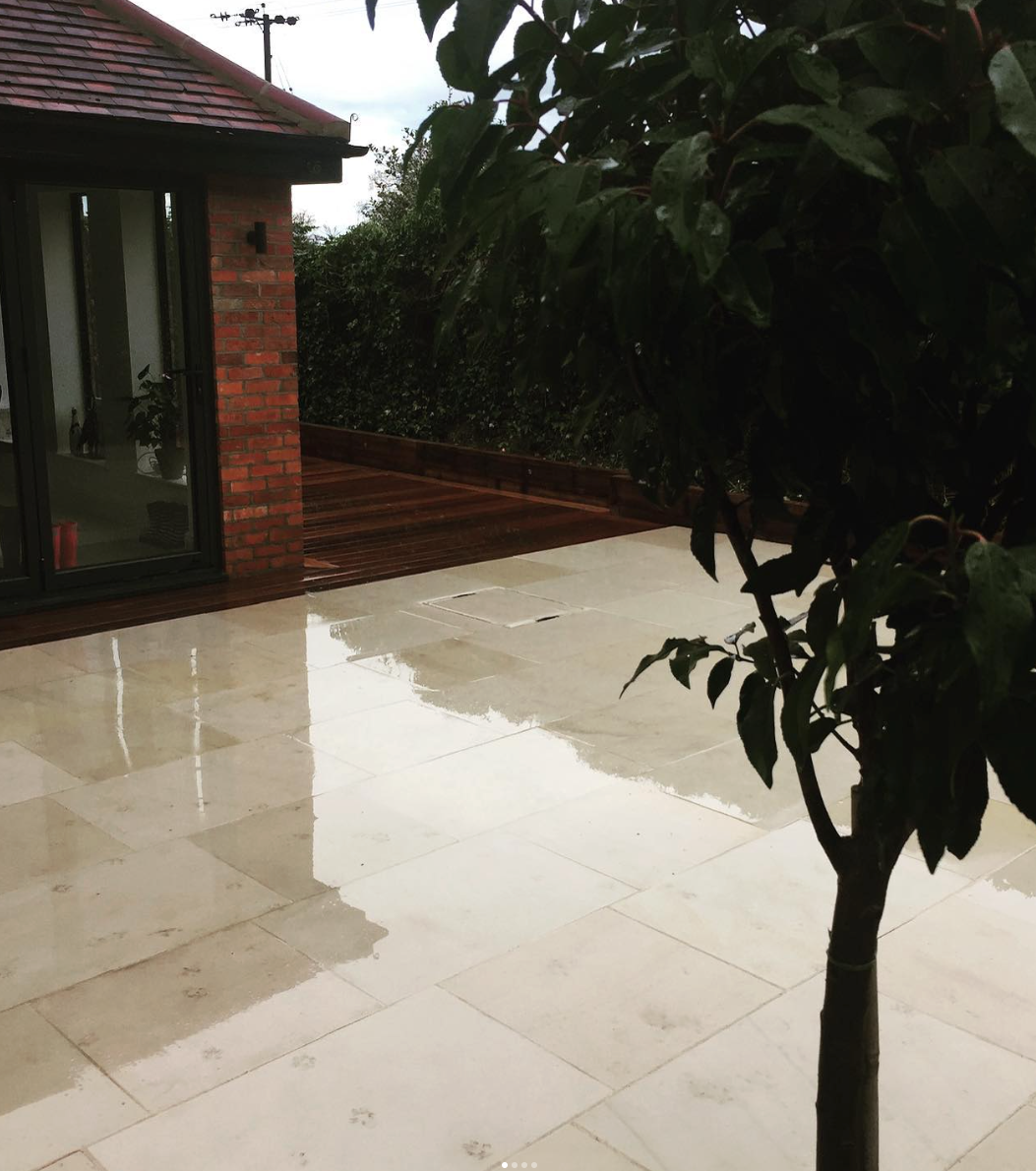 Image shows a newly laid patio with a tree in the foreground