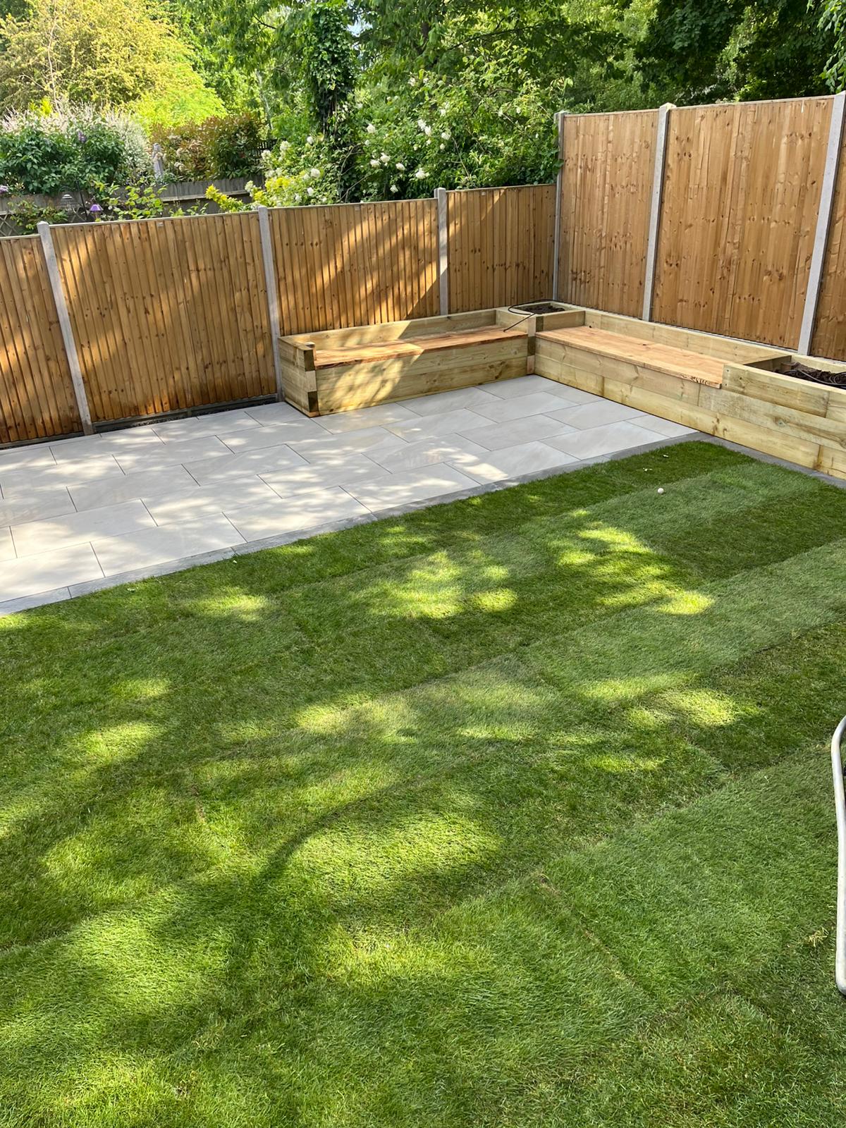 Image shows newly laid turf and a newly installed patio. Image depicts lawn care services