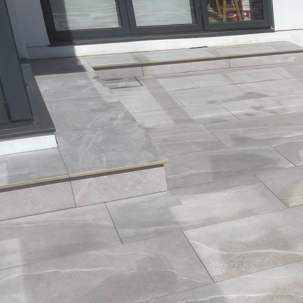 Image shows a newly laid patio with step. Image depicts local Hertfordshire garden landscapers